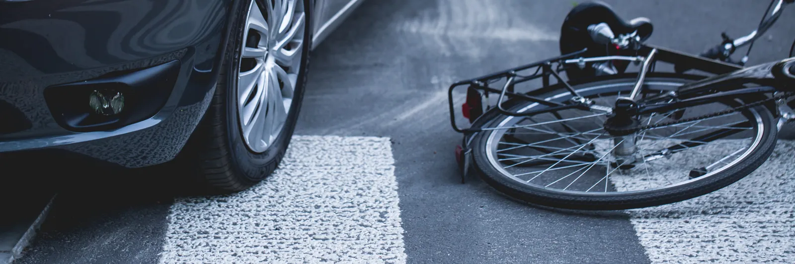 Vélo couché sur un passage piéton à côté d'une voiture après un accident — droits et indemnisation du cycliste victime