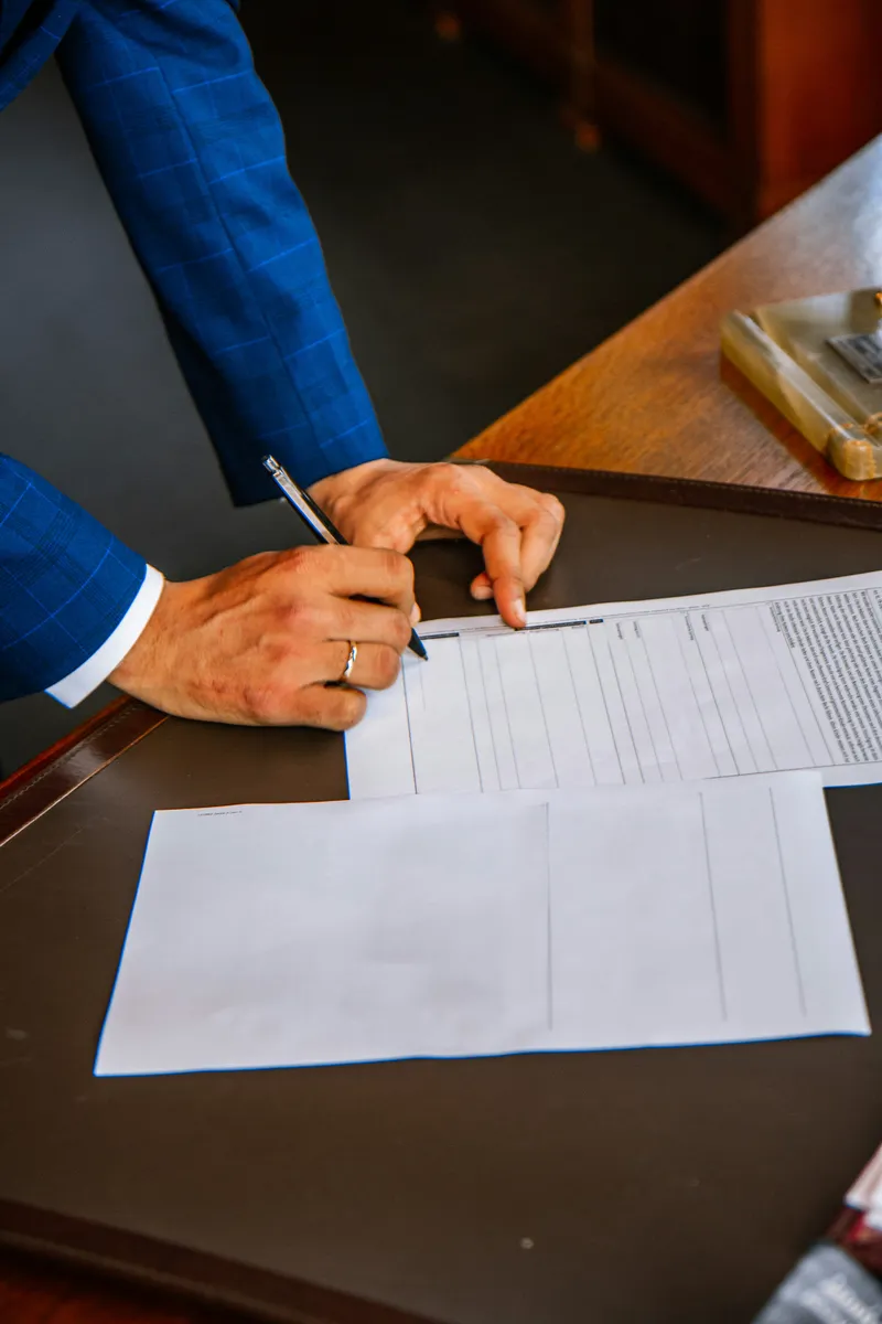 Homme en costume signant un document juridique