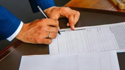 Homme en costume signant un document juridique