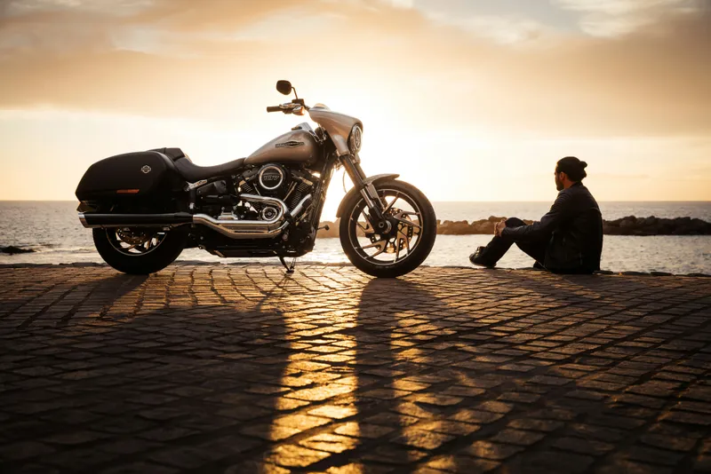 Moto à l'arrêt au coucher du soleil au bord de l'eau