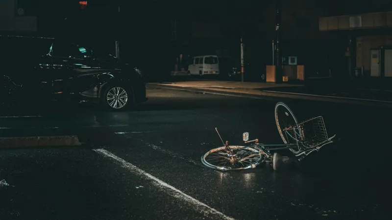 Vélo à terre sur une route la nuit près d'une voiture