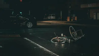 Vélo à terre sur une route la nuit près d'une voiture