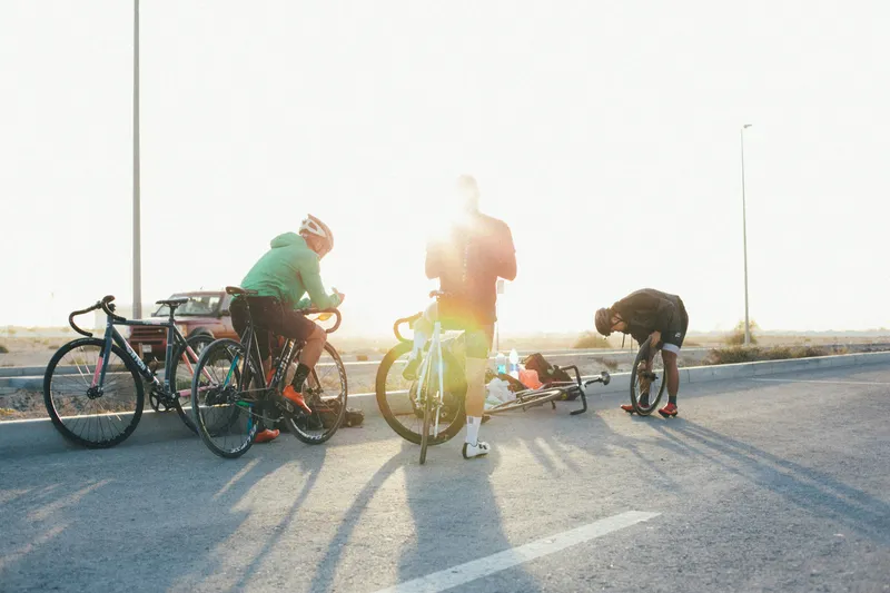 Groupe de cyclistes sur la route au coucher du soleil