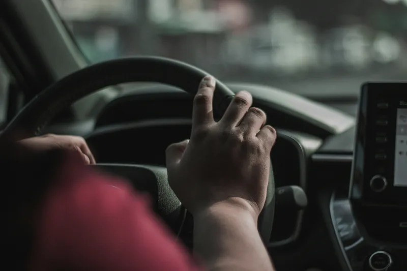 Mains d'un conducteur sur le volant d'une voiture